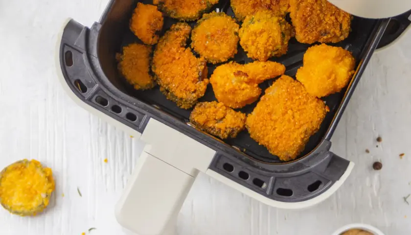 Verdure in friggitrice ad aria, dorate e croccanti, pronte per essere gustate. Un'idea sana e veloce per uno snack o un contorno.