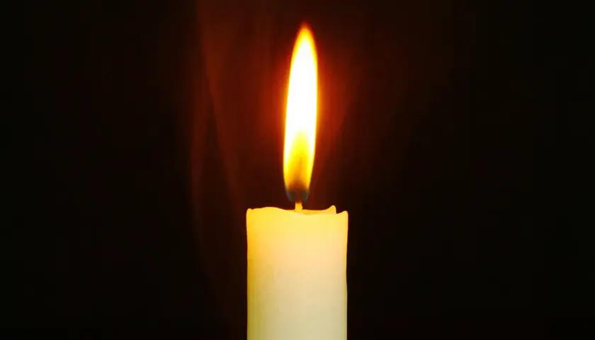 Jasny płomień świecy, niczym nieuchwytna dusza, tańczy w ciemności, rzucając ciepłe światło.