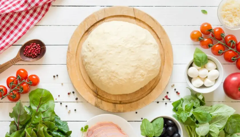 Świeże ciasto na pizzę, pomidorki, mozzarella, oliwki i bazylia. Zastanawiasz się, ile może stać ciasto na pizzę?