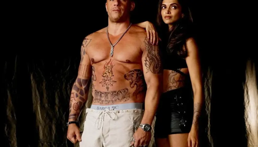 Vin Diesel med tatueringar och en kvinna i mörka kläder, en scen som påminner om hans filmer.