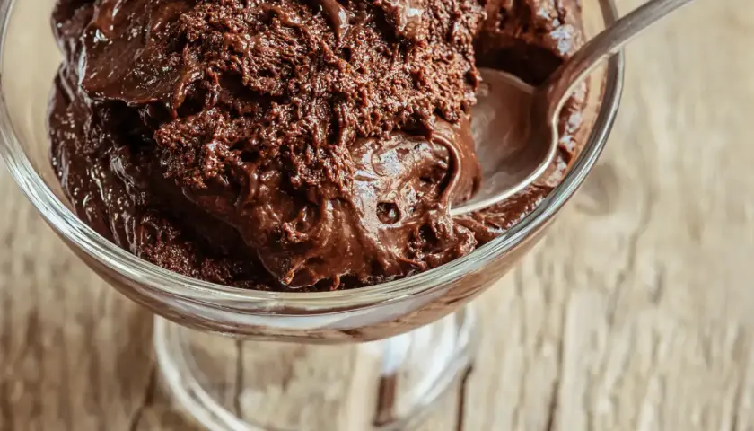 Une coupe de verre remplie de mousse au chocolat maison, prête à être dégustée. La texture est riche et onctueuse, parfaite pour la conservation.