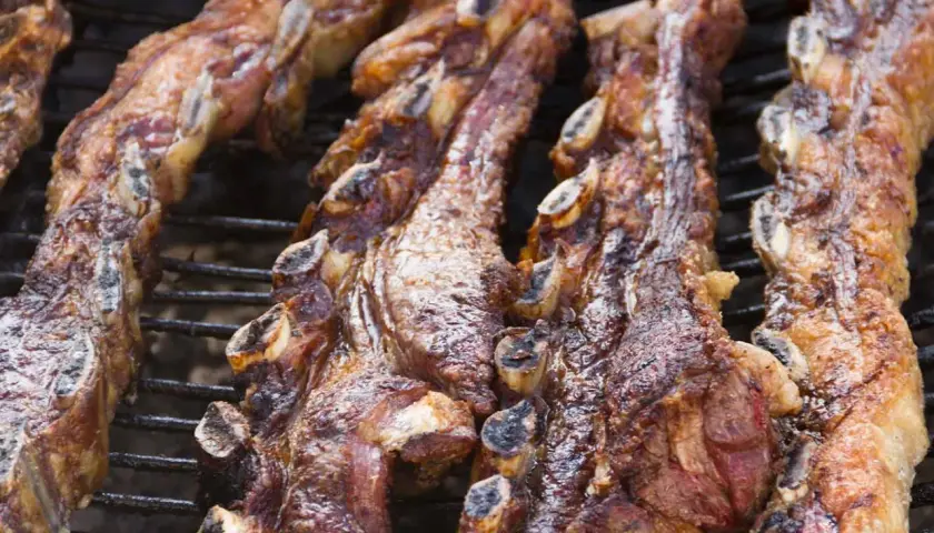 Costillas de churrasco al horno, doradas y jugosas, listas para disfrutar en una parrilla.