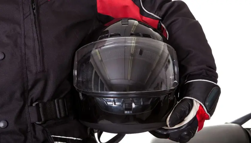 Motociclista con casco negro y chaqueta roja. Aprende como poner pinlock para evitar vaho.