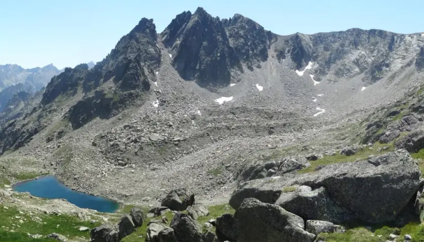 Majestuosas montañas rocosas y un lago azul turquesa en el valle de Aneu.