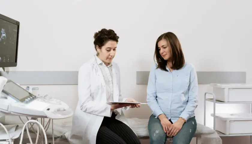 Medico spiega a paziente i risultati di un esame, forse un ecografia, discutendo del cerchiaggio cervicale.