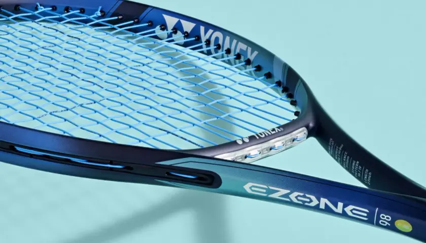 Niebieska rakieta tenisowa Yonex EZONE 98 z niebieskimi naciągami. Yonex to znana firma produkująca sprzęt sportowy.