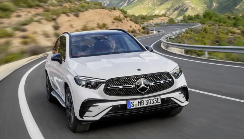 Weißer Mercedes GLC 300 de Hybrid auf kurviger Bergstraße. Technische Daten im Blick, bereit für jede Fahrt.