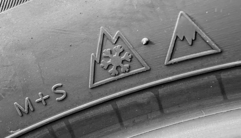 Symbole pneu 4 saisons : flocon de neige dans une montagne et inscription M+S.