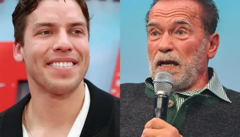 Uśmiechnięty Joseph Baena obok Arnolda Schwarzeneggera przemawiającego do mikrofonu.
