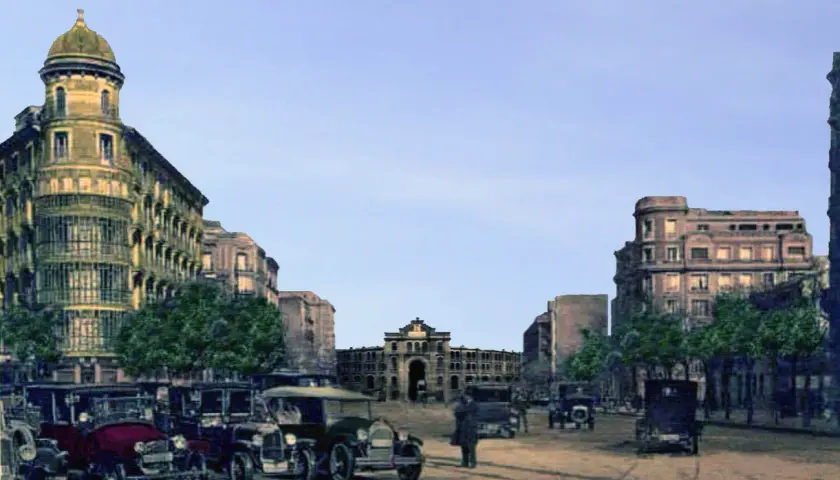 Vista de la antigua plaza de toros de Madrid, con edificios históricos y coches de época.