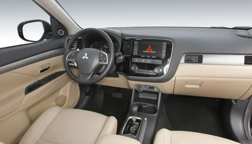 Interior de Mitsubishi Outlander 2.2 Di-D 150. El tablero, asientos y consola central beige sugieren un coche bien cuidado, a pesar de posibles problemas.