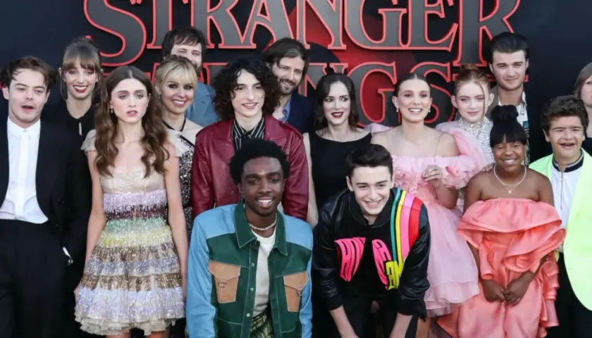 Aktorzy Stranger Things pozują do zdjęcia. Widać tu m.in. Millie Bobby Brown, Finn Wolfhard, Winona Ryder i David Harbour.