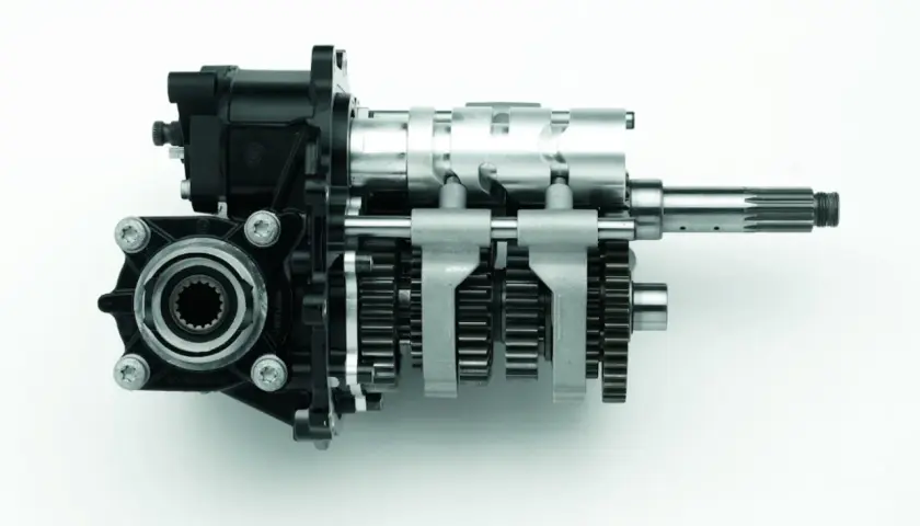 Mechanizm zmiany biegów z widocznymi kołami zębatymi i wałkami, pokazujący, jak działa skrzynia biegów.