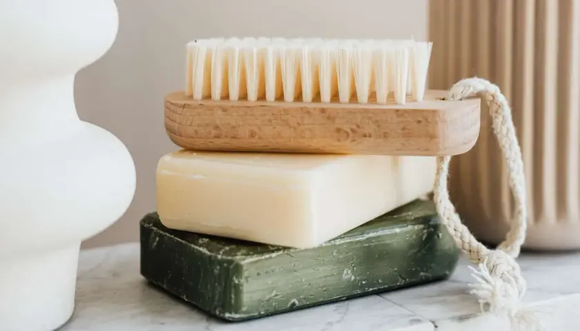 Jabón de azufre para que sirve: una pila de jabones y un cepillo de madera.