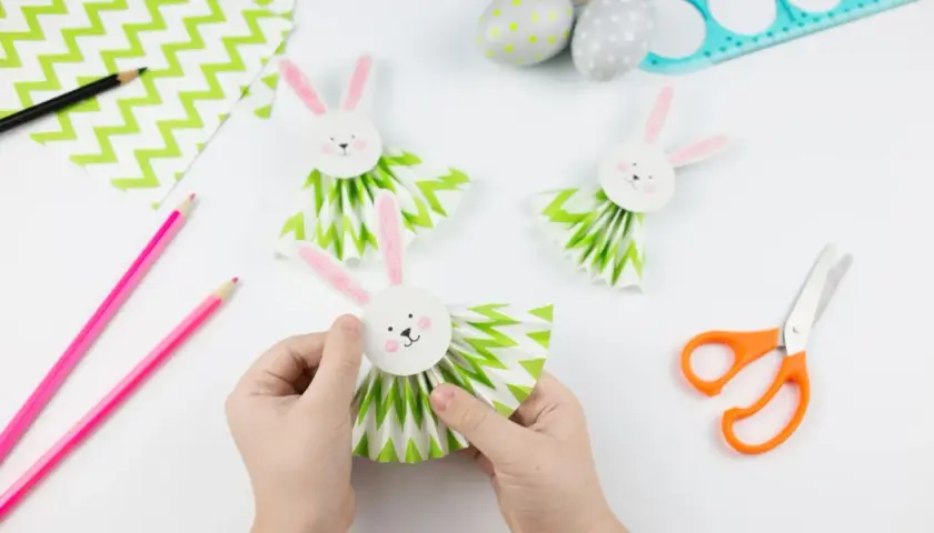 Osterbasteln mit Kindern Grundschule: Kleine Hände basteln süße Papierhasen mit Fächerkörpern. Bunte Ostern kann kommen!