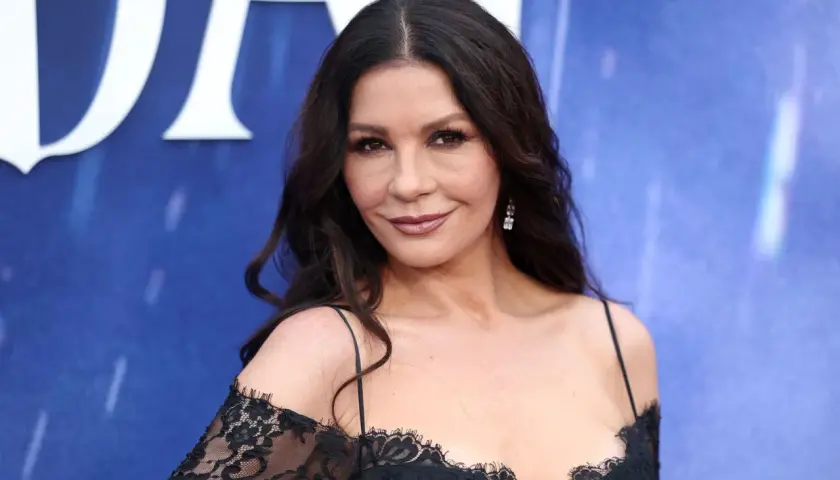 Catherine Zeta-Jones, której walijskie pochodzenie widać w jej urodzie, pozuje w czarnej, koronkowej sukni.