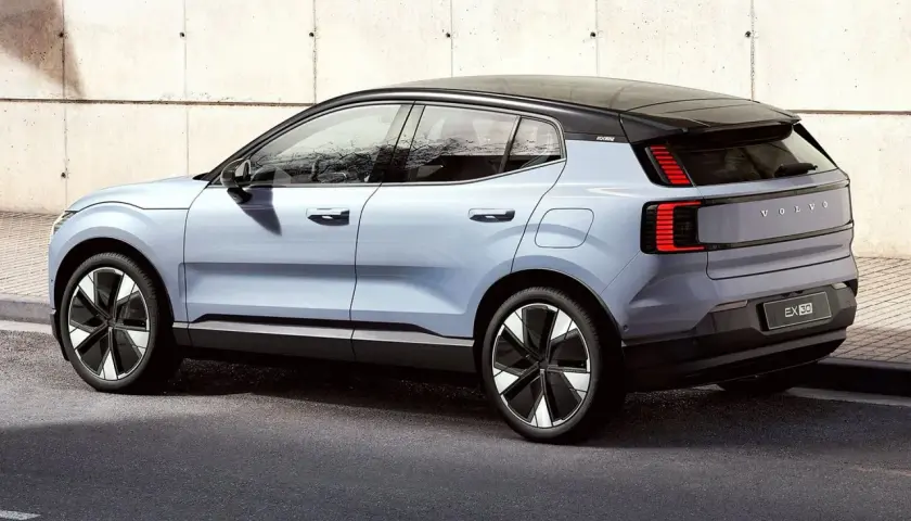 Nowy, elektryczny Volvo EX30 w kolorze jasnoniebieskim prezentuje się nowocześnie na tle betonowej ściany.