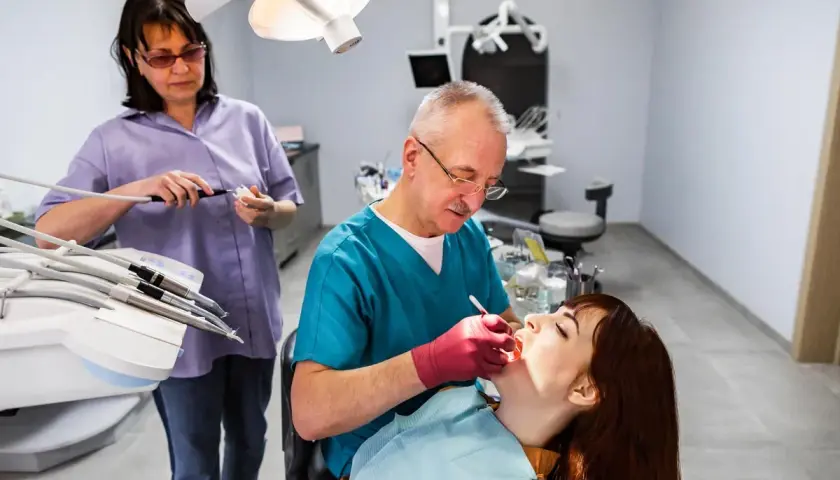Dentista esamina una paziente. L'alitosi quando preoccuparsi? Chiedi al tuo dentista.
