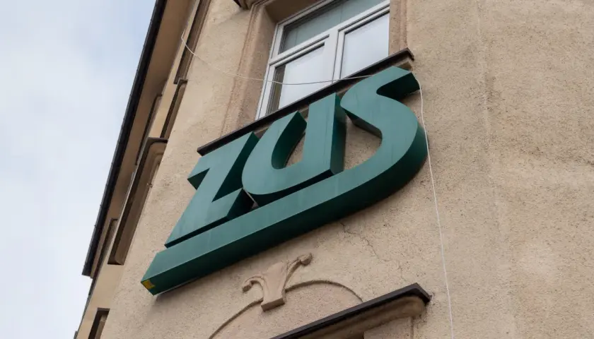 Zielone logo ZUS na budynku. Warto wiedzieć, jak wynagrodzenie chorobowe a składki ZUS wpływają na Twoje finanse.