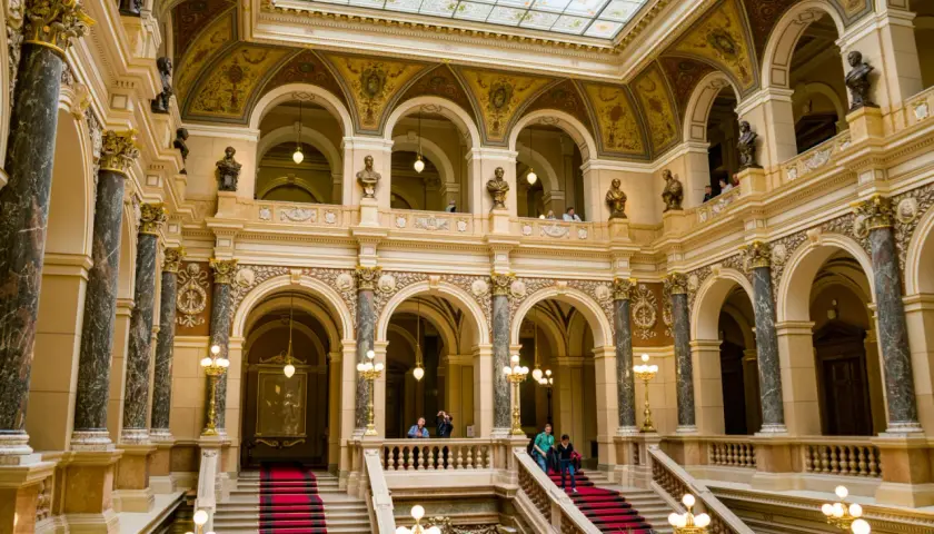Wnętrze muzeum w Pradze, Czechy. Marmurowe kolumny, złote zdobienia i czerwone dywany na schodach tworzą majestatyczny widok.