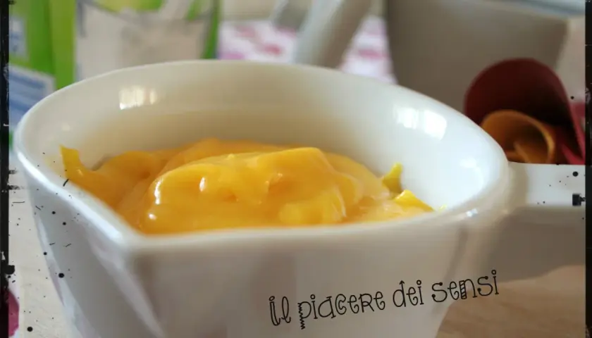 Crema pasticcera ricetta della nonna, densa e vellutata, servita in una ciotola bianca. Un dolce abbraccio di sapori.