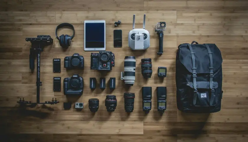 Sprzęt filmowca: kamery, obiektywy, dron, stabilizator, słuchawki, tablet, lampy błyskowe i plecak. Każdy element to mały co to piksel, tworzący obraz.
