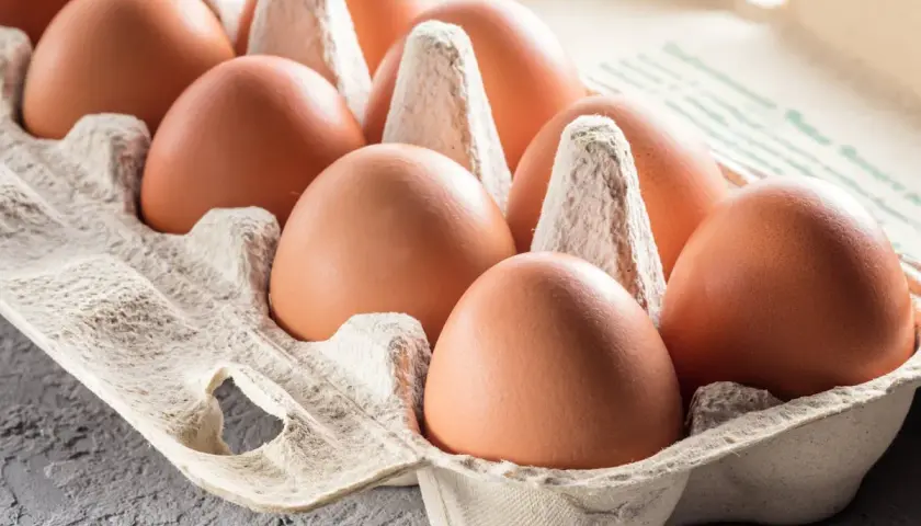 Des œufs bruns dans une boîte en carton. On hésite à manger un œuf après la date, par prudence.