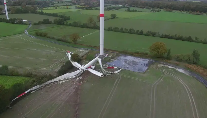 Ein Windrad Unfall hat die Rotorblätter zerfetzt. Trümmer liegen verstreut auf dem Feld neben dem intakten Turm.