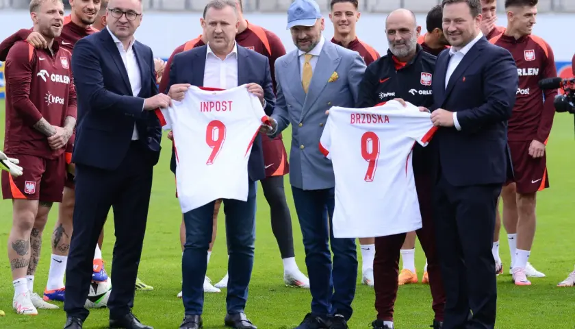Piłkarze reprezentacji Polski z koszulkami od sponsorów. Wśród nich widać logo InPost i Orlen.