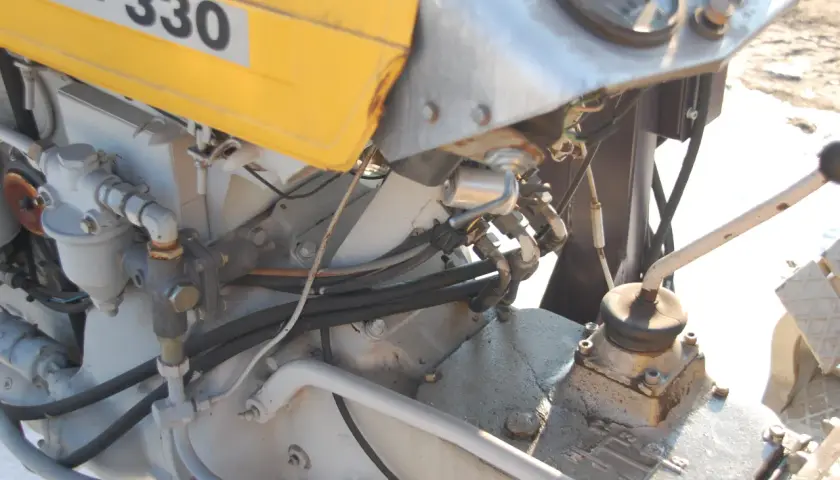 C-330 z wspomaganiem elektrycznym. Widoczny fragment silnika, przewody hydrauliczne i dźwignia zmiany biegów.