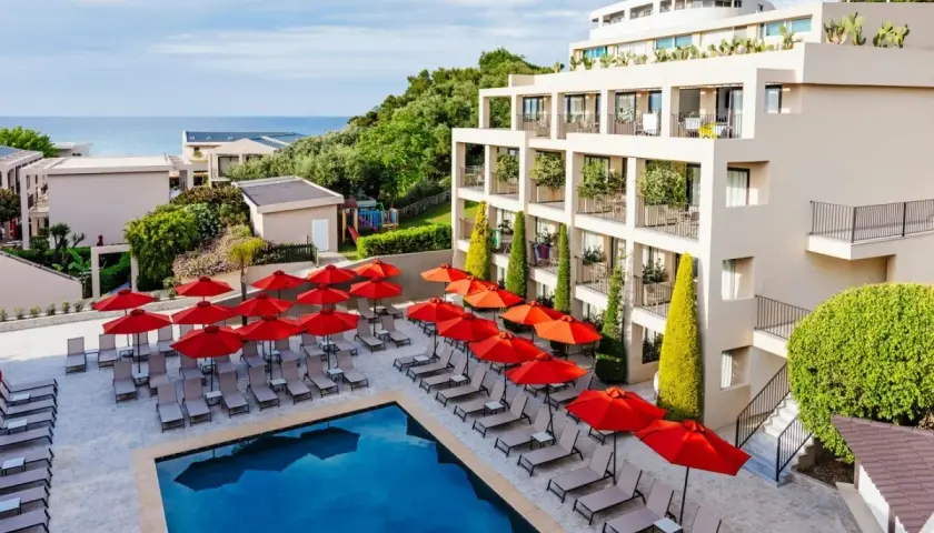 TUI Suneo Tsilivi Admiral: basen z leżakami i parasolami, nowoczesny hotel, morze w tle.