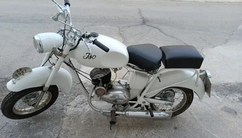 Ciclomotor histórico blanco, modelo Iso, con asiento doble y detalles cromados.