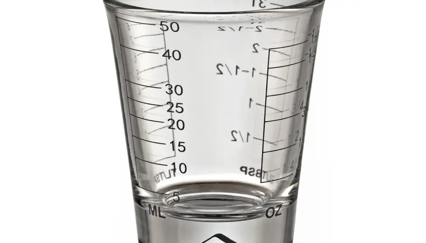 Szklany kieliszek z miarką, o pojemności do 50 ml, idealny do precyzyjnego odmierzania składników.