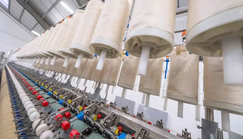 Machine à filer le lin en France, avec de grands rouleaux de fil prêts à être transformés.