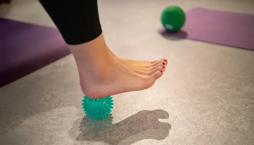 Fußmassage mit Igelball: Ein Hausmittel, das gegen Fersensporn helfen kann.