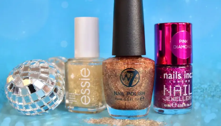 Glittrigt w7 nagellack i kopparfärg, bredvid Essie och Nails Inc. En discokula och glitter ger festlig känsla.