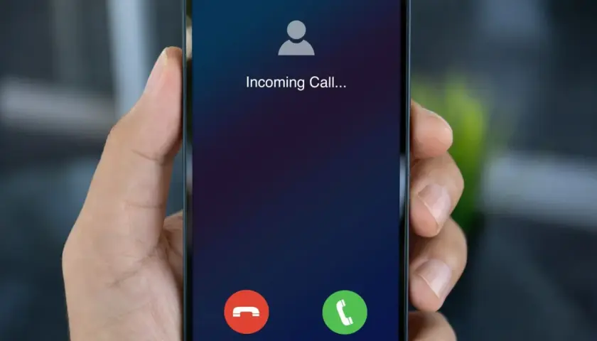 Dłoń trzyma smartfon z ekranem "Incoming Call...". Dowiedz się, jak dzwonić przez internet za darmo, by zawsze być w kontakcie.
