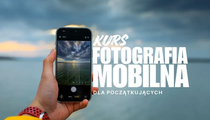Dłoń trzyma smartfon, na ekranie którego widać zachód słońca nad wodą. Napis "KURS FOTOGRAFIA MOBILNA DLA POCZĄTKUJĄCYCH" zaprasza do nauki.