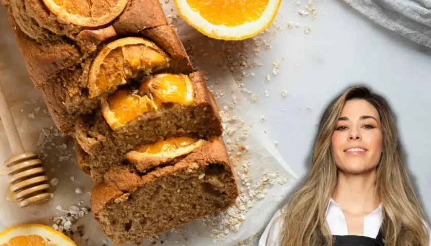 Un delicioso bizcocho de naranja, decorado con rodajas de naranja y avena, junto a una mujer sonriente.