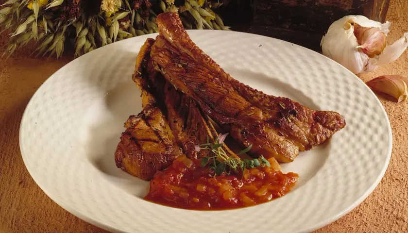 Saftiga spareribs i ugn, serverade med en smakrik tomatsalsa och garnerade med färska örter. En härlig måltid!