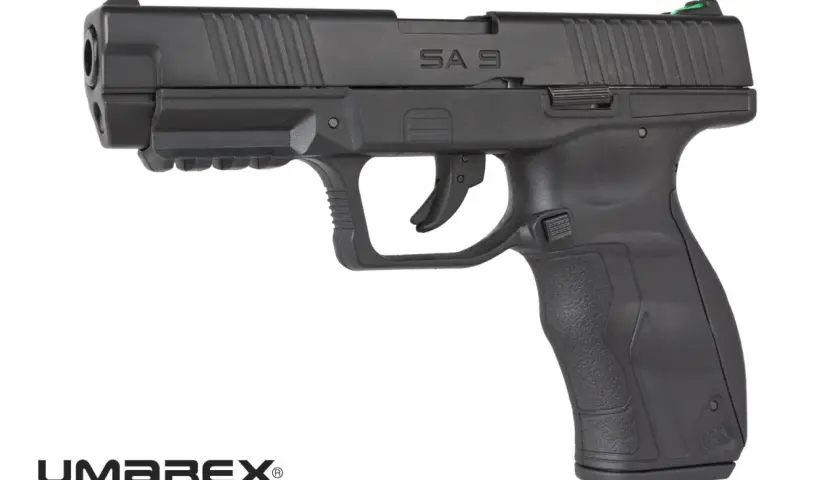 Czarny pistolet Umarex SA10 z zieloną muszką, gotowy do akcji.