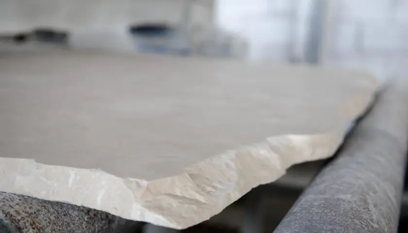 Surowy, jasny wapień na linii produkcyjnej. Kamień czeka na dalszą obróbkę.