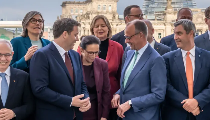 Politiker posieren vor dem Reichstag. Sie scheinen über die Bildung einer Koalition zu sprechen, was bedeutet, dass verschiedene Parteien zusammenarbeiten, um eine Regierung zu bilden.
