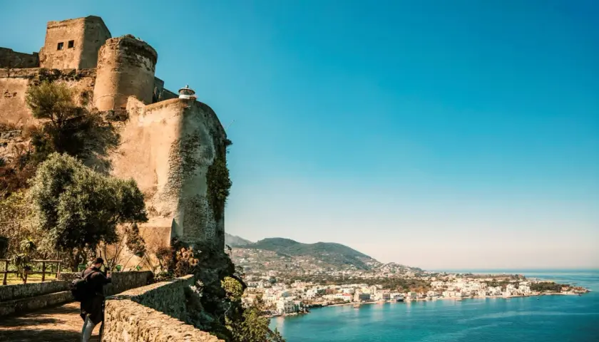 Antico castello a picco sul mare, con vista sulla costa di Ischia. Un fotografo cattura la bellezza del panorama, un ricordo di Ischia Castel Sant'Angelo.