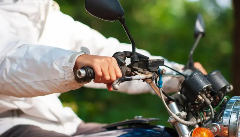 Mano sujetando el acelerador de una moto, con la llave del gas abierta, lista para la aventura.