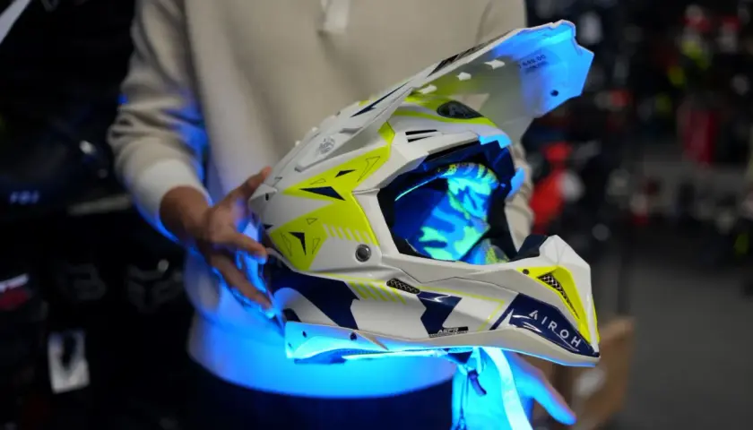 Biało-żółte kaski enduro z niebieskim podświetleniem, gotowe na ekstremalne wyzwania.