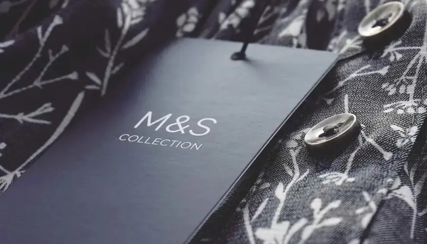 Étiquette M&S Collection sur un tissu fleuri. Astuce pour savoir comment décoller une étiquette sans l'abimer.