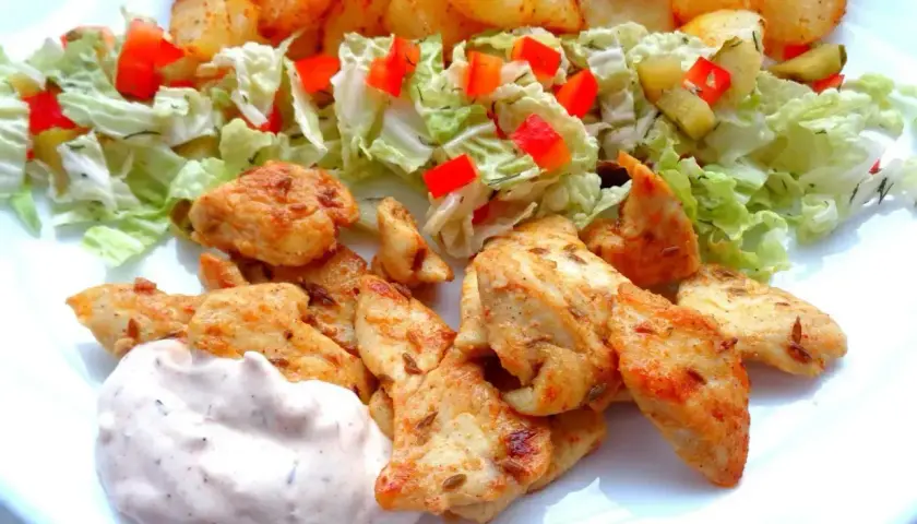 Pyszna shoarma z kurczaka z chrupiącymi ziemniaczkami i świeżą sałatką.