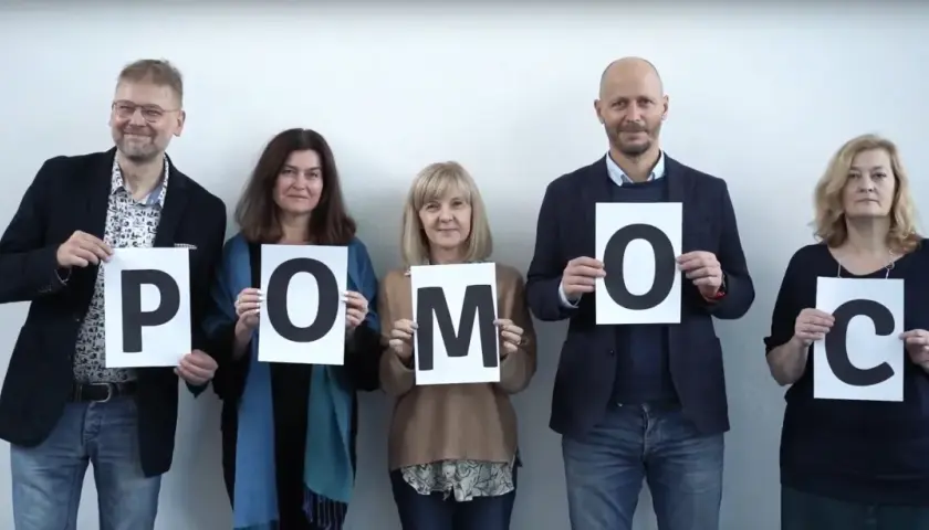 Pięć osób trzyma litery tworzące słowo POMOC. To przykład, co to altruizm – bezinteresowna pomoc innym.