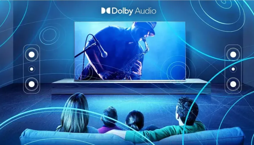 Rodzina ogląda koncert saksofonisty na ekranie telewizora, ciesząc się kinowym dźwiękiem Dolby Digital Plus.